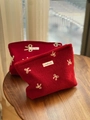 Makroaufnahme von roten Filztaschen mit Bogenstickerei und Simple Wish Etikett-Detail - Rote Wolle Kleine Schleife