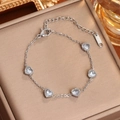 Pulsera de acero de titanio plateada con cinco cristales de circonita de corazón - Color Acero Circón Blanco