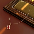18K vergulde ketting met rode kalebas hanger en hartdetail op een groene vintage basis - Rode Agaat / Goud