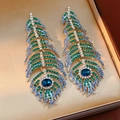 Detalle macro de pendientes de pluma de pavo real vintage con diamantes azules y verdes - Estilo Pluma (HE30694) / Azul-Verde (Base Plateada)