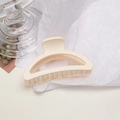 Primo piano di una molletta per capelli crema opaca su carta ruvida bianca minimalista - Semicerchio / Bianco Sporco