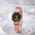 Detail of rose gold watch with deep green dial and crystal markers on glass tray - Green Dial