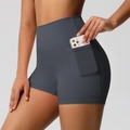 Detail of high-waisted gray yoga shorts with a side pocket holding a mobile phone - Graphite Grey