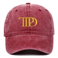 Macro detail of yellow TTPD embroidery on a washed burgundy cotton baseball cap - One Size / Burgundy