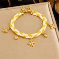 Detail of hand-woven rope bracelet with gold-plated flower pendants and clear zircons - Yellow-White Clover Zirconia Style (B1798)