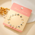 Set of 7 silver stud earrings featuring stars, crowns, and clovers on display card - Silver Music Cat Paw (E1933-1)