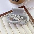Close-up of acetic acid flower hair claw clip with rhinestones in a jewelry tray - Grey