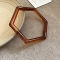 Macro-detail van de geometrische zeshoekige barnsteenhars armband met schildpadmotief - Hexagonaal geometrisch ontwerp / Koffie Barnsteen Patroon