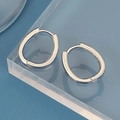 Macro detail of polished S925 sterling silver oval hoop earrings on acrylic stand - Oval Hoop Earring / Silver