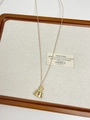 Macro view of golden money bag pendant with dollar sign on beige textile background - Gold Money Bag