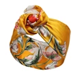 Detailansicht des ingwergelben Blumen-Samtstirnbands mit seidiger Textur und Knotendesign - Lilie Gelb