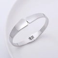 Dettaglio del bracciale rigido minimalista in argento lucido su un piatto bianco - Color Acciaio