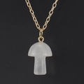 Detailed macro view of white crystal mushroom pendant on a delicate gold metal chain link - White Crystal