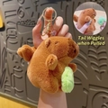 Brown capybara plush keychain with green leaf and functional pull-string wagging tail - Pull String Ball Capybara Dark Brown