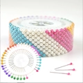 Colorful pearl head pins arranged in a round white storage wheel for sewing and pinning - Colorful