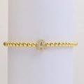 Nahaufnahme eines goldenen Perlenarmbands mit glitzerndem Zirkonia-Buchstabe A - Buchstabe A