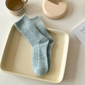 Thick light blue ribbed knit wool crew socks displayed in a cozy home setting - One Size / Blue