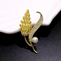 Elegant gold wheat brooch with yellow crystals and a white pearl on dark background - Golden Wheat Crystal Pearl