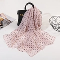 Lightweight pink chiffon scarf with black polka dots draped over a black handbag - Small Polka Dot Pink