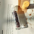 Clear glass essential oil roller bottle filled with red crystal gravel and wood cap - Garnet