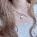 Détail du nœud rose et du médaillon cœur gravé sur un collier de perles blanches - Style Médaillon Coeur Rose (Or)