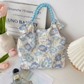 Detail of floral tote bag with blue woven rope handles and vibrant butterfly patterns - Blue Floral