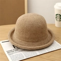 Detailed close-up of khaki knit bucket hat texture on a warm wooden tabletop - Khaki