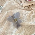Détail d'une pince à cheveux papillon gris lilas avec ressort doré sur nappe en dentelle - Fermoir papillon / Env. 8cm / Gris Ciment