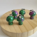 Natural ruby in zoisite mushroom pendants with metal loops on a wooden stand - Ruby Zoisite