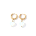 Détail de boucles d'oreilles anneaux dorés avec pendentifs cœur en pierre laiteuse - Or + Opale