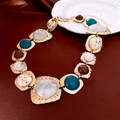 Detailed shot of vintage gold necklace with colorful resin stones on dark red fabric - Necklace #4 - Gold - Blue - White