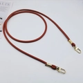 Close-up of brown PU leather bag strap with polished gold metal swivel clasps - Light Brown + Gold Hook