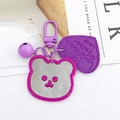 Dettaglio del portachiavi a specchio a forma di orso viola con cuore e piccolo campanello - Viola