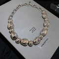 Dettaglio della collana argentata con perle irregolari e catena in metallo stile minimal - Argento