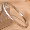Minimalist silver titanium steel curved bangle with smooth finish on jewelry box - 4mm / Steel