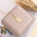 Close-up of gold Virgin Mary pendant with cubic zirconia on a luxury beige jewelry box - Oval Lace Relief Style (3#)