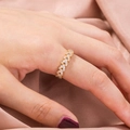 Anillo elegante de hoja dorada con circonitas cúbicas sobre fondo de satén rosa - Diseño de Hoja de Pluma / Dorado