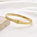 Minimalist hollow gold-plated stainless steel bangle on a modern white stone base - Geometric 3D Style (Style 3)