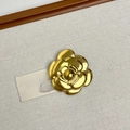 Detailed view of a layered gold camellia brooch on a textured neutral fabric background - 23 Gold Camellia Flower (Z-4600)