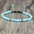 Detailed close-up of 4mm natural blue stone beads and golden spacers on a woven bracelet - Turquoise