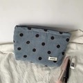 Detailed close-up of corduroy polka dot makeup bag on white fabric with beauty props - Fog Blue Polka Dot Pouch
