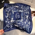 Detailed close-up of navy blue silk scarf featuring artistic horse and floral prints - Dark Blue