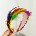 Detail of colorful feather headband featuring vibrant rainbow plumage on a beige band - Multicolor Feather Headband