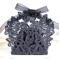 Detailed view of black laser-cut butterfly gift box with ribbon bow for wedding candy - Black