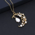 Gros plan du collier lune et étoile doré avec pierres précieuses blanches en forme de goutte - Blanc