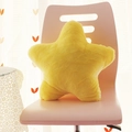Yellow star-shaped plush decorative pillow placed on a pink chair in a home setting - Yellow Pentagram