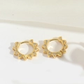 Macro shot of gold hoop earrings with sunburst spikes and shimmering zircon stones - Gear Style (ES2821-1)