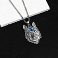 Gros plan détaillé d'un pendentif tête de loup en argent avec une pierre précieuse bleue - Tête de Loup aux Yeux Bleus