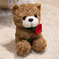 Brown curly teddy bear plush toy with a red rose decoration sitting on a soft rug - Brown Rose Bear