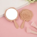 Elegant beige rose-shaped hand mirror with matching makeup brushes on a pink surface - Solid Lotus Pink